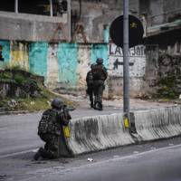 Soldiers take part in a crackdown on crime gangs in the Lins de Vasconcelos slum complex in Rio de Janeiro on Saturday. Troops storm Rio slums to catch gang leaders