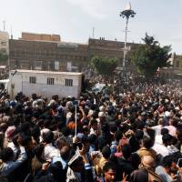 People gather around a police truck carrying the body of Muhammad al-Maghrabi, 41, after he was executed for raping and murdering a 3-year-old girl, in Sanaa Monday. | REUTERS