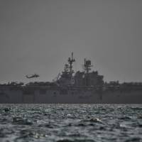 The USS America, which is supporting ongoing search for missing crew members of USS John McCain, is seen in Singapore waters Monday. U.S. destroyer collision exposes 40-year Singapore-Malaysia sea dispute