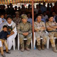 Members of Kurdish forces attend a commemoration to mark three years since Islamic State launched what the United Nations said was a genocidal campaign against Yazidi, in Sinjar region, Iraq, Thursday. | REUTERS