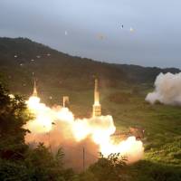 South Korea’s Hyunmoo II Missile system (left) and a U.S. Army missile system fire missiles during a combined military exercise at an undisclosed location in South Korea on July 29. Pentagon reviewing missile guidelines with South Korea