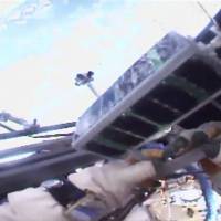 In this image made from video provided by NASA, Russian cosmonaut Sergei Ryazansky holds a mini satellite before launching it by hand from the International Space Station on Thursday. Spacewalking cosmonauts release world's first 3-D-printed satellite