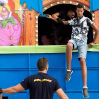 African migrants are detained by police as they are discovered hidden inside a traveling amusement park truck on their way to cross to the Spanish mainland city of Algeciras from Spain’s North African enclave of Ceuta Monday. Heartbeat detectors, dogs turn up 30 African migrants hiding in Spain-bound fairground rides in Ceuta