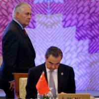 U.S. State Secretary Rex Tillerson passes by the table of Chinese Foreign Minister Wang Yi at the start of the 7th East Asia Summit Foreign Ministers’ Meeting and its dialogue partners as part of the 50th ASEAN Ministerial Meetings in Manila Monday. U.S. ready to talk if North Korea stops its missile tests, Tillerson says