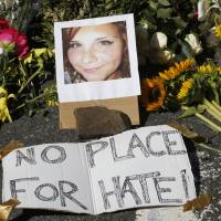 A makeshift memorial of flowers and a photo of victim Heather Heyer are seen in Charlottesville, Virginia, Sunday. Heyer died when a car rammed into a group of people who were protesting the presence of white supremacists who had gathered in the city for a rally. Social injustices caused Charlottesville melee victim to weep, her boss says