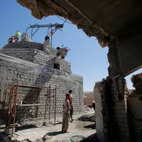 Workers rebuild a Yazidi shrine, after is was destroyed by Islamic State, in Bashiqa, a town near Mosul, Iraq, Tuesday. Yazidis rebuild Islamic State-razed Bashiqa shrine during long wait for female abductees' return
