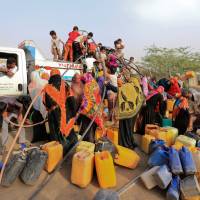 People gather around a charity tanker truck to fill up their jerrycans with drinking water in Bajil of the Red Sea province of Hodeidah, Yemen, Saturday. | REUTERS