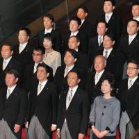 New Cabinet members line up and pose at the Prime Minister’s Office in Tokyo on Thursday. Struggling in polls, Abe puts premium on stability in Cabinet shake-up