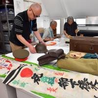Volunteers sort out personal items donated by relatives of people who experienced World War II at the Material Pavilion of War and Peace Aichi in Nagoya. Japanese war memorabilia pile up at museums, while online auctions of artifacts remain unregulated