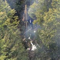 Debris from what is believed to be a small plane that crashed in a mountainous part of the village of Yamazoe, Nara Prefecture, is seen from a helicopter on Monday. | KYODO