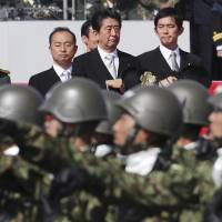 Prime Minister Shinzo Abe reviews members of the Self-Defense Forces during a parade at a military base in Asaka, Saitama Prefecture, in October. Japan Defense Ministry warns of North Korean nuclear, missile advances in annual report