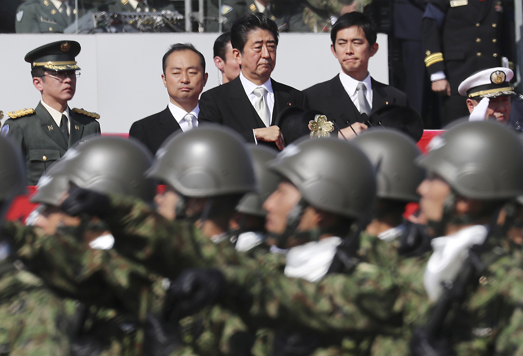 Prime Minister Shinzo Abe reviews members of the Self-Defense Forces during a parade at a military base in Asaka, Saitama Prefecture, in October. | AP