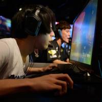 Participants compete in an e-Sports event in Tokyo on July 1. Laws curbing organized crime and gambling are preventing gaming competitions with high prize money from being held in Japan. If not for yakuza laws, Japan could be cleaning up in e-sports ring
