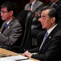 Chinese Foreign Minister Wang Yi (right) and Foreign Minister Taro Kono listen to Philippine Foreign Secretary Alan Peter Cayetano’s opening remarks during the 18th ASEAN Plus Three Foreign Ministers Meeting in Manila on Monday. Kono urges China to learn 'how to behave as a big power'