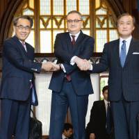 Deputy Foreign Minister Takeo Akiba (right), Russian Deputy Foreign Minister Igor Morgulov (center) and Eiichi Hasegawa, special advisor to the prime minister, pose ahead of a meeting of sub-Cabinet-level officials in Moscow on Thursday. Japan, Russia officials agree to aim for September accord for joint activities on disputed isles