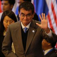 Foreign Minister Taro Kono waves at the start of the 7th East Asia Summit Foreign Ministers\' Meeting and its dialogue partners as part of the 50th Association of Southeast Asian Nations (ASEAN) regional security forum in Manila on Monday. | POOL / VIA AFP