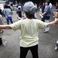 A woman exercises in Tokyo in September 2016. Kyoto Prefectural University of Medicine and Hirosaki University will launch a survey in the Tango district in northern Kyoto Prefecture to study the longevity of residents there. Universities in Kyoto, Aomori to probe contrasting longevity