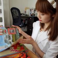 Online celebrity Chunhun, a leading voice among young women fascinated with North Korean culture, flips through a photo album of North Korean leader Kim Jong Un at the home of a like-minded friend in Tokyo on July 27. Drawn to North Korea's culture, Japanese internet star looks beyond the saber-rattling