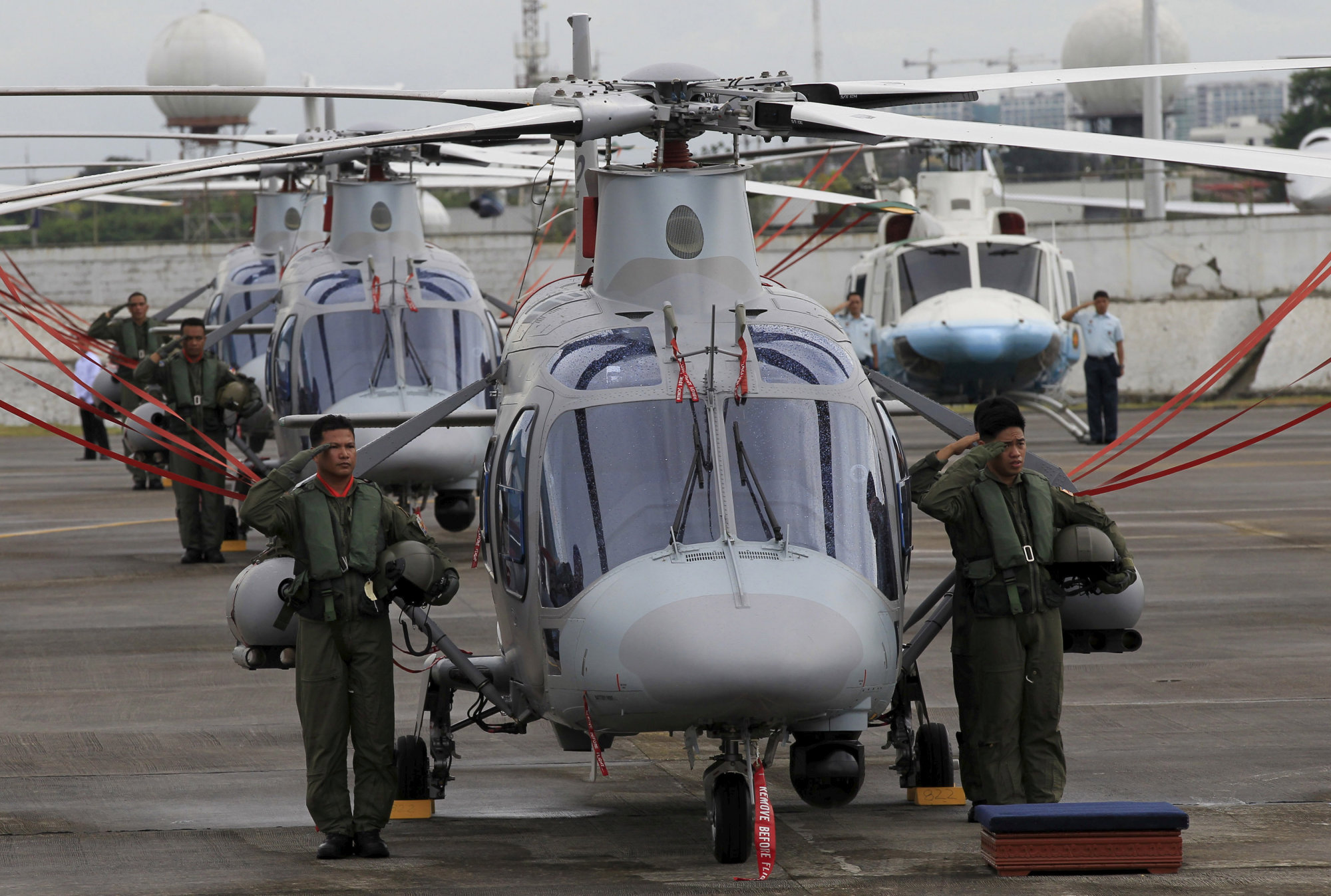 Philippine Air Force pilots stand next to newly acquired AgustaWestland AW109E helicopters during a ceremony at Villamor Air Base in Manila in December 2015. | REUTERS