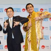 Piko Taro is seen with Foreign Minister Fumio Kishida and an unidentified woman at a promotional event for the U.N. Sustainable Development Goal at United Nations\' headquarters in New York on July 17. | KYODO