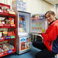 An official shows off confectioner Ezaki Glico Co.’s Office Glico service in May 2016 in the city of Osaka. Self-service convenience store stands and kiosks popping up inside companies