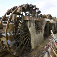 Japan\'s oldest working water wheels, located in Asakura, Fukuoka Prefecture, began turning again Wednesday after soil and debris that accumulated around them following torrential rain in the area last month was removed. | KYODO