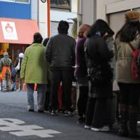 People wait in a line to collect food distributed by Second Harvest Japan. | NATSUKI YASUDA / STUDIO AFTERMODE