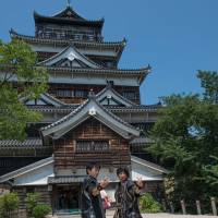 Playing a role: Costumed actors assume martial poses outside Hiroshima Castle. | STEPHEN MANSFIELD