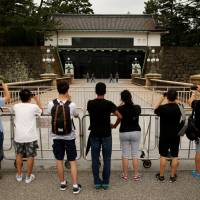 The perfect picture: Visitors observe the changing of the Imperial Guard officers at the Imperial Palace in Tokyo. Japan’s top tourist destinations have seen a rise in visitors and in some cases their presence is impacting the lives of residents. Japan grapples with its new arrivals