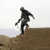 A U.S. special forces soldier climbs down from a compound wall after investigating suspicious activity in Shewan, Afghanistan, in November 2009. The war in Afghanistan that goes on forever