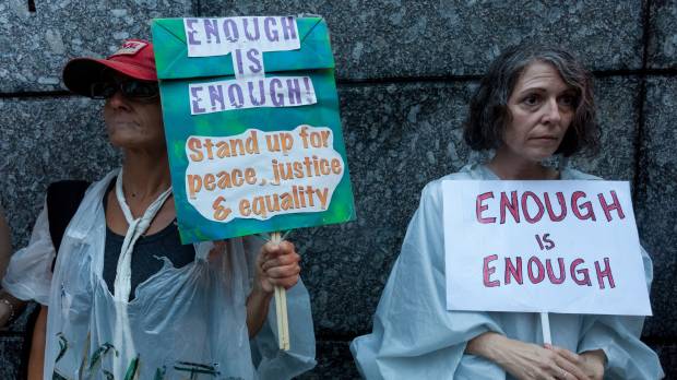 Time to take a stand: Organizers Sarajean Rossitto (left) and Jenise Treuting hold placards at the “Enough is Enough” rally near the U.S. Embassy in Toranomon, Tokyo, on Aug. 15, days after hate groups clashed violently with anti-fascist counterprotesters in Charlottesville, Virginia. Trump or decency? Every American, whether in Japan or elsewhere, must choose a side