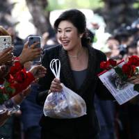 Ousted former Thai Prime Minister Yingluck Shinawatra greets supporters on Tuesday as she arrives at the Supreme Court in Bangkok, where she is on trial for negligence over a rice subsidy scheme that could see her imprisoned for up to 10 years. Trial of Yingluck sparks deeper crisis for Thailand
