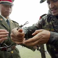 Chinese and Indian soldiers install a barbed wire fence at the Nathu La border crossing between India and China in India’s Sikkim state in June 2006. On Monday, India and China said their troops were disengaging from a standoff on the Doklam plateau, a strategically important disputed territory in the area where the borders of China and Bhutan meet. India and China provide rare glimmer of hope