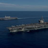 The USS Ronald Reagan (foreground) and the Maritime Self-Defense Force helicopter destroyer JS Izumo sail in formation during a combined exercise involving the MSDF and U.S. Navy on June 15. Japan's maritime diplomacy mission in S.E. Asia