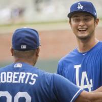 Dodgers pitcher Yu Darvish talks with manager Dave Roberts before Los Angeles’ game against the Braves on Thursday in Atlanta. Darvish thanks Rangers fans in full-page ad