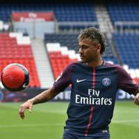 Paris Saint-Germain’s Neymar plays with a ball during his official presentation at Parc des Princes stadium in Paris on Friday. Neymar arrives at PSG, says money wasn't motivation for move to France