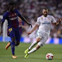 Barcelona’s Samuel Umtiti (left) and Real Madrid’s Karim Benzema vie for the ball in the second leg of the Spanish Super Cup on Wednesday in Madrid. Real Madrid polishes off Barcelona sans Ronaldo, captures Spanish Super Cup