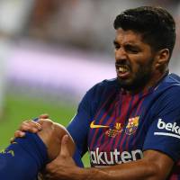 Barcelona’s Luis Suarez grimaces after being injured during the second leg of the Spanish Super Cup against Real Madrid on Wednesday night. Barca loses Suarez for four weeks with injury