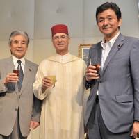 Moroccan Ambassador Rachad Bouhlal (center) poses for a photo alongside Hirofumi Nakasone (left), president of the Japan-Morocco Parliamentary League, and Nobuo Kishi, state minister of foreign affairs, during a reception at Palace Hotel Tokyo on July 31 to celebrate the anniversary of Mohammed VI\'s accession to the throne. | YOSHIAKI MIURA