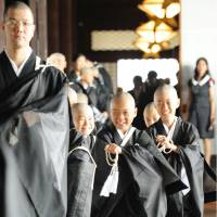 Children leave a ceremony at Higashi Honganji Temple in Kyoto on Friday after becoming monks. Before attending the event, they had their heads shaved and received black stoles and were given Buddhist names. | KYODO