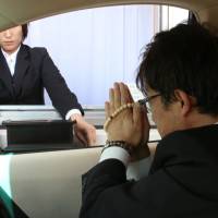 People demonstrate a drive-thru funeral service allowing the bereaved to give their final farewells from their car. Drive-thru funeral service will let Japanese bid an easy and fast last farewell