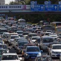 Cars clog a street in Beijing on Monday. China is gearing up to ban gasoline and diesel cars, a move that would boost electric vehicles and shake up the auto industry in the world’s biggest but pollution-plagued market. China eyes ban on fossil fuel cars, putting its own EV makers ahead of world's auto giants