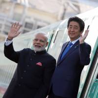 Prime Minister Shinzo Abe and Indian leader Narendra Modi wave after a visit to Kawasaki Heavy Industries Ltd.’s Rolling Stock Co. plant in Kobe last November. Japan's bullet train tech to give 164-year-old Indian railway a jolt
