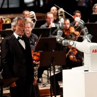 Humanoid robot YuMi conducts the Lucca Philharmonic Orchestra performing a concert alongside Italian tenor Andrea Bocelli at the Verdi Theatre in Pisa, Italy, Tuesday. Robot 'conductor' steals show from Italy's top tenor Bocelli but can't improvise