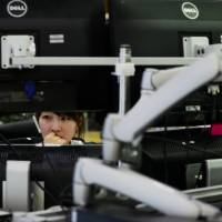 A foreign-exchange dealer watches a currency monitor in a trading room. The yen may advance to 100 against the dollar by year-end, according to HSBC Holdings. HSBC sees yen at 100 against dollar within months as Japan falters on inflation