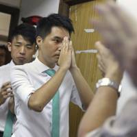 Pro-democracy activist Sulu Sou (center), 26, celebrates with his supporters Sunday after he won a seat in voting, the same day, for the semi-democratic legislature in Macau, China. Macau elects young democracy activist, as opposition drive out casino-related representatives