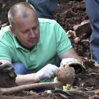 Bosnian forensic exper, Murat Hurtic inspects a set of human remains at the site of a newly discovered mass grave in the village of Tugovo, near Eastern-Bosnian town of Vlasenica, on Sept. 13. The remains of about 20 victims from Bosnia’s 1990s civil war, most likely Bosnian Muslims, have been exhumed from two newly discovered mass graves, the Missing Persons Institute said. Bosnia mass grave so far yields at least 65 skulls of alleged executed non-Serb civilians