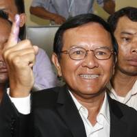 Kem Sokha, leader of the Cambodia National Rescue Party, shows off his ink-covered finger after voting at a polling station in Phnom Penh on June 4. Cambodian opposition leader Kem Sokha arrested for treason