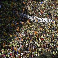People hold a banner reading “Independence now!” in Catalan as they gather during a pro-independence demonstration Monday in Barcelona, Spain, during the National Day of Catalonia, the “Diada.” Mass Catalan fete focuses on right to say adios to Spanish rule
