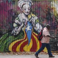 This Barcelona work by the street artist “Zecarrion” shows a woman sewing a pro-independence Catalan flag, with the Spanish flag in a trash can nearby. Catalonia launches independence challenge against Spain